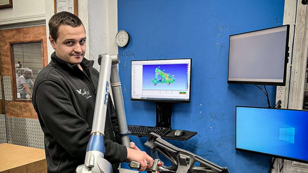 Eagle CNC staff member using FARO laser scanning arm to review tolerances on a part