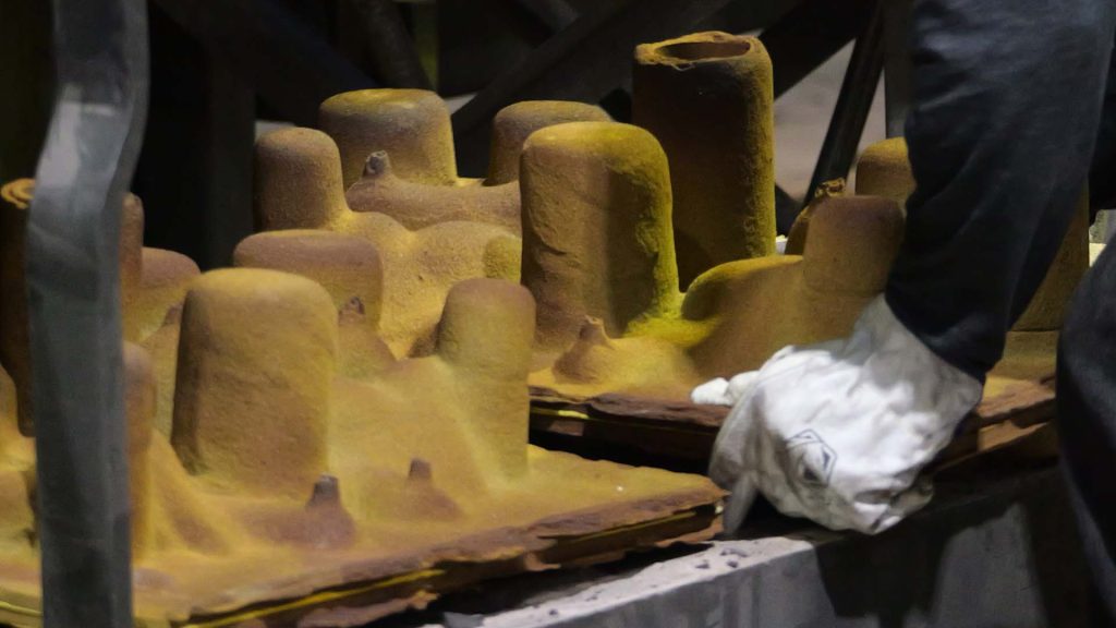 Shell molding: operator placing shell mold in rack